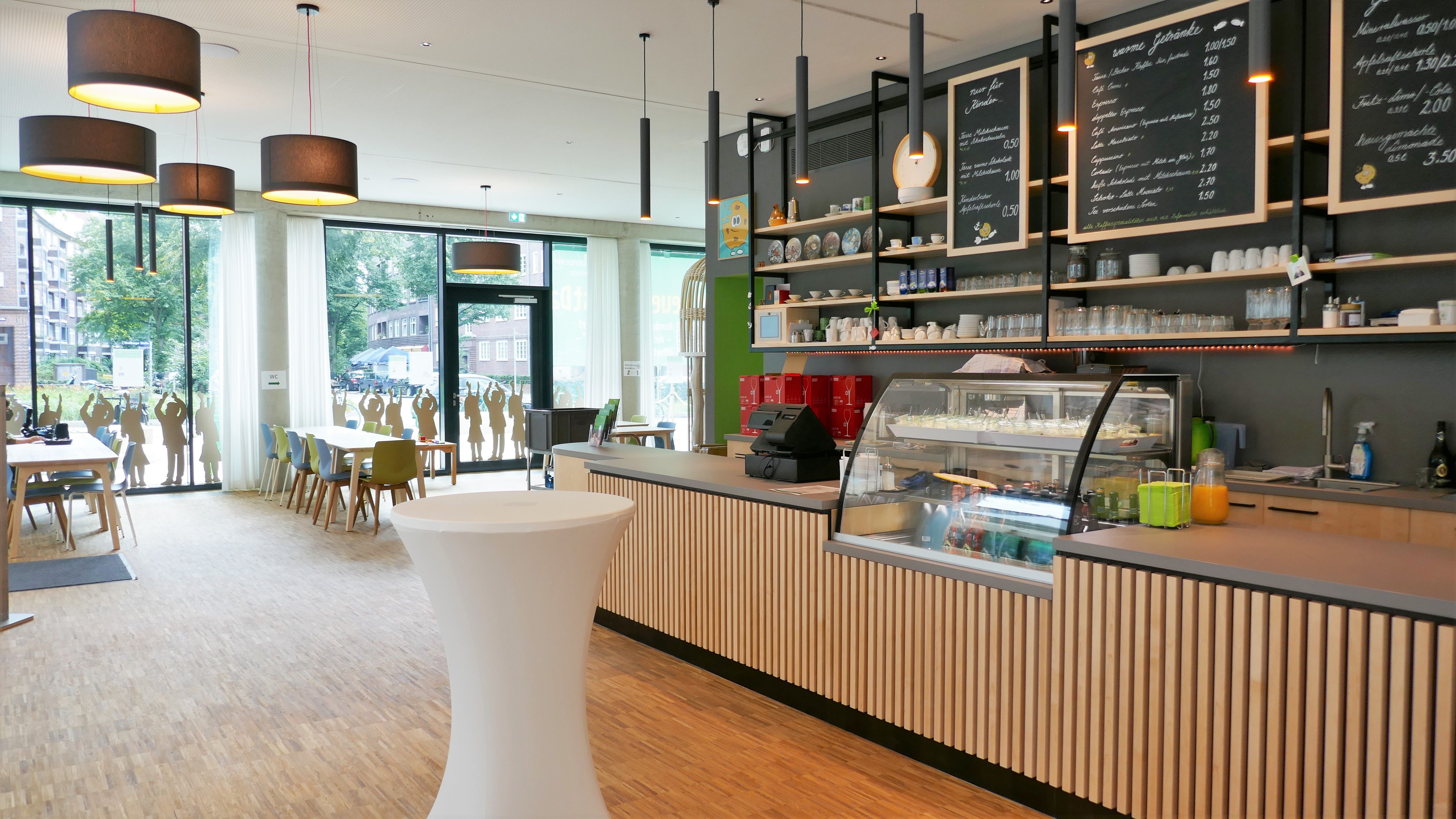 Tresen, Tische und Stühle im Inneren des SOS-Familiencafé in Hamburg.